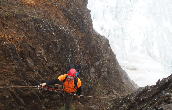 Cody Pink repels down mountain into glacier.