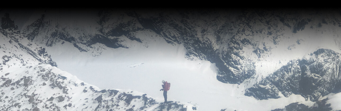 Cody Pink stands on Alaskan mountain ridge.